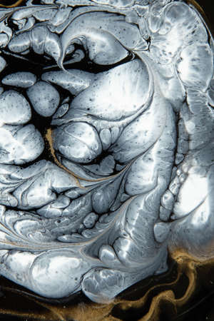 Abstract painting with epoxy resin. Marble circles in black, white and gold colors. Abstract modern veined liquid background for design.の写真素材