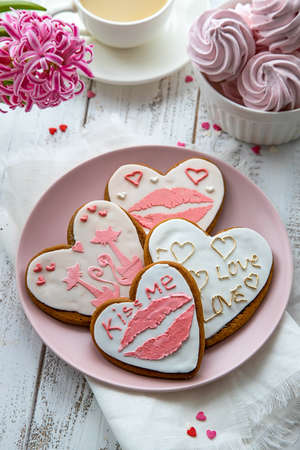 Gingerbread hearts on a wooden background with inscriptions and a pattern, prepared for Valentine's Day. Love flat lay.の写真素材