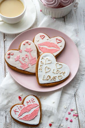 Gingerbread hearts on a wooden background with inscriptions and a pattern, prepared for Valentine's Day. Love flat lay.の写真素材