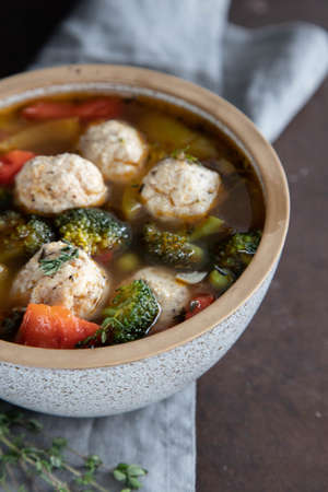 Delicious vegetable soup with meatballs in a bowl,top view on a wooden background.の写真素材