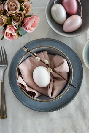 Serving a festive table for Easter. Plate with napkin and egg, top view. Festive tableの写真素材