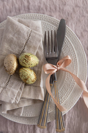 Serving a festive table for Easter.Little eggs on a white plate,close up. Festive table