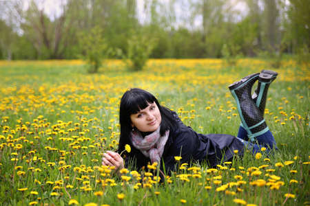 woman lying on the field with dandelionsの写真素材