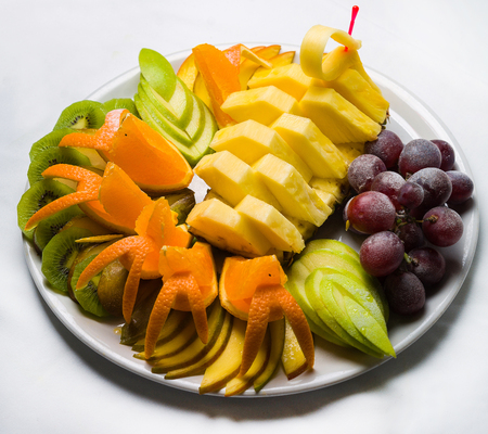 Big plate with lots of healthy fruits over white backgroundの写真素材