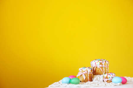 Yellow background colorful Panettone Kulich cakes with easter eggs. Depth of field