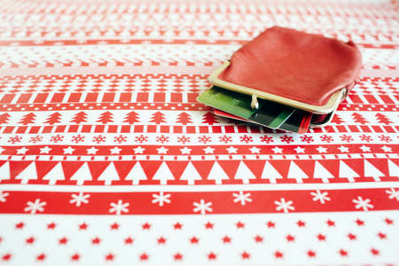 Red wallet with credit cards on a christmas wrapping paper. Christmas expenses concept