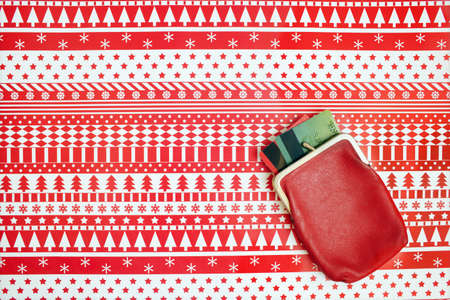 Red wallet with credit cards on a christmas wrapping paper. Christmas expenses concept