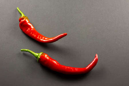 Red hot chili peppers two pieces close-up on a dark backgroundの写真素材