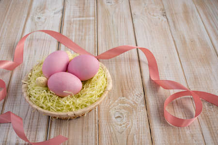 Easter eggs in a nest on a wooden background. Happy Easterの写真素材