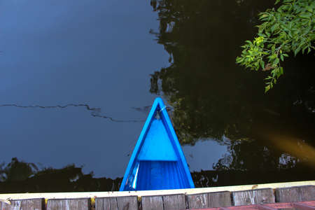 Blue boat on the river under a bridgeの写真素材
