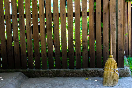 Rural wooden fence and a straw broomの写真素材