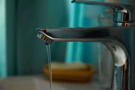 Faucet poring water dark sceneの写真素材