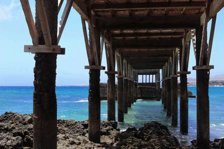 wooden bridge over the sea where the water hitsの写真素材