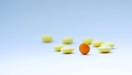 tablets, yellow and one orange, orange symbolizes the sun, everything turns around pharmacology, blue background similar to the skyの写真素材