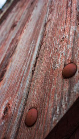 old wooden boards are painted with red paint, have peeled off under the influence of an environment,...