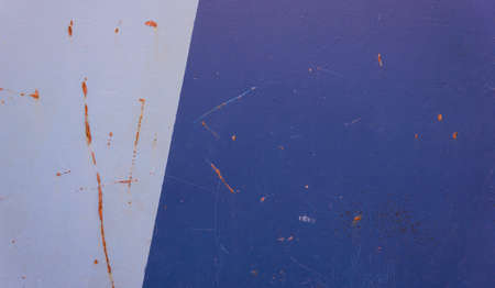 the part of the rusty metal gate covered with blue paint dark and light, dividing them into several...