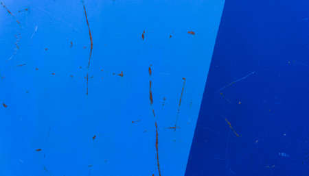 the part of the rusty metal gate covered with blue paint dark and light, dividing them into several partsの写真素材