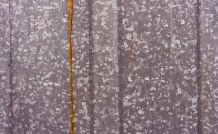 part of the metal gate of a gray shade divided into several parts by strips and a rustの写真素材