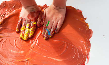 the small child of preschool age draws on paper hands and palmsの写真素材