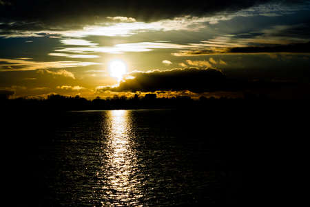 sunset in autumn in November, a bright yellow, brown and black colors, to sit round the sun, cloudsの写真素材