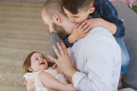 Dad and two children have a fun at home.の写真素材