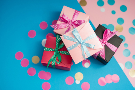 Decorated boxes and confetti on the pink and blue background.