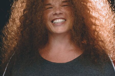 Portrait of ethnic redhead curly-haired woman with freckles.の写真素材