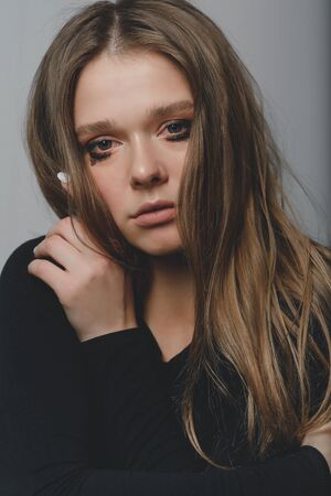 Portrait of a young beautiful long-haired girl who is upset crying.の写真素材