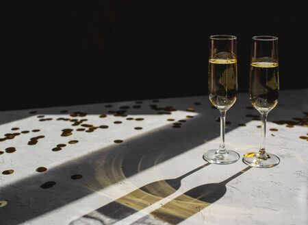 Two glasses of champagne in golden confetti.の写真素材