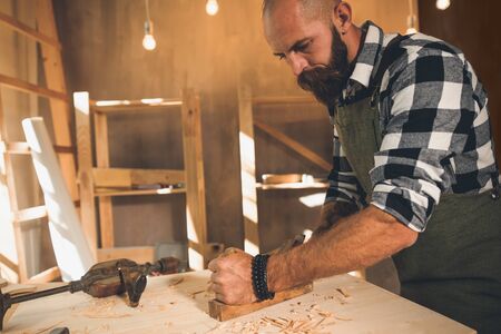 Portrait of a young male carpenter who works in his workshop.