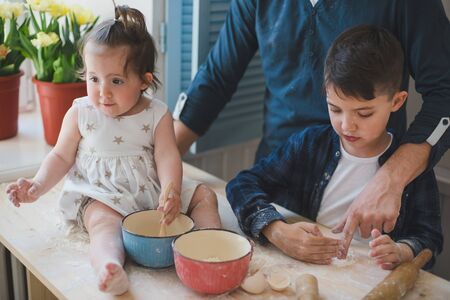 Cropped photo dad with his little son and daughter baking together.