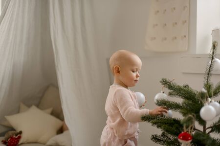 Cute little baby girl plays in a spacious bright minimalistic childrens room.の写真素材