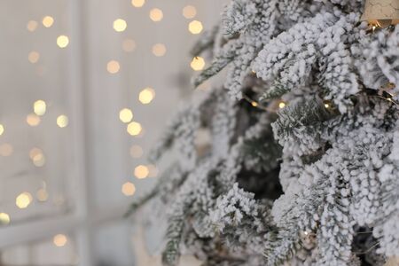 A fragment of a beautiful, elegant Christmas tree against a background of bright, luminous garlands.