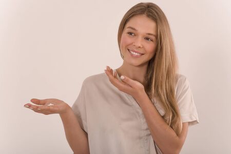 Portrait of a young beautiful woman with a drop of cream on her palm.の写真素材