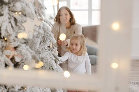 Family Christmas morning in a bright minimalistic living room near the Christmas tree.の写真素材