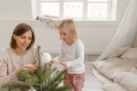 Cute little baby girl with her mom play in a spacious bright minimalistic childrens room.の写真素材