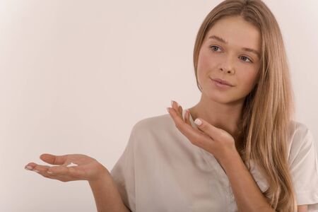 Portrait of a young beautiful woman with a drop of cream on her palm.の写真素材