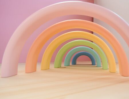 Abstract figures from elements of the children's designer wooden pastel rainbow on a wooden podium on a paper background. The idea of balance, balance, sustainable design, eco-friendly lifestyle, childhood, creativity.の写真素材