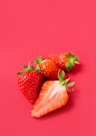 Ripe juicy orgaic strawberries on a red background.の写真素材