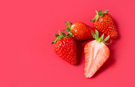 Ripe juicy orgaic strawberries on a red background.の写真素材
