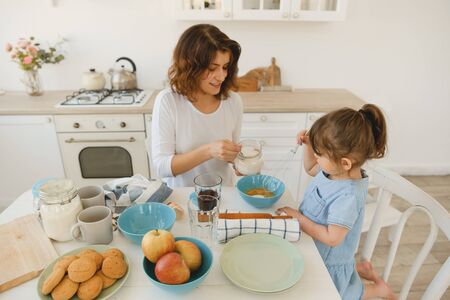 A young mother spends time with her little daughter at home.の写真素材