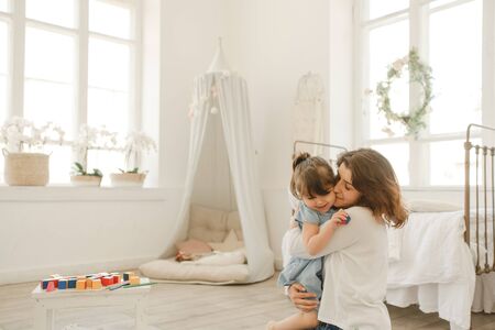 A young mother spends time with her little daughter at home.の写真素材