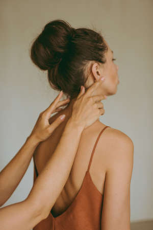 Female hands gently touch the young attractive brunette woman.の写真素材