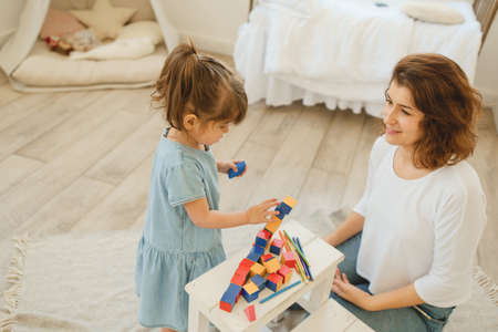 A young mother spends time with her little daughter at home.の写真素材