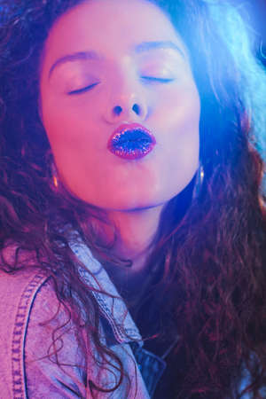 Young beautiful woman with long curly hair in ultraviolet light.