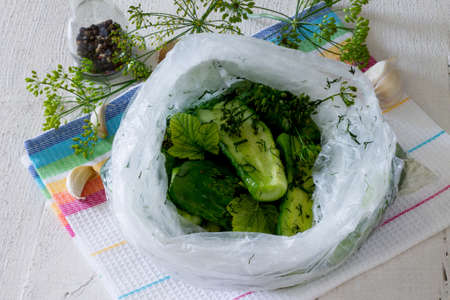 Fresh pickled cucumbers with dill and garlic on a wooden tableの写真素材