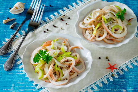 Salad and pepper squid with onions  on a wooden tableの写真素材