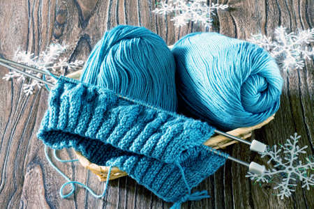 Wool yarn and needles. Needlework accessories on wooden background.