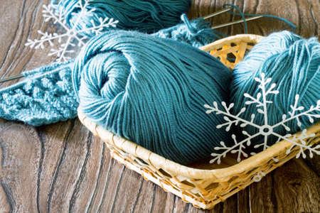 Wool yarn and needles. Needlework accessories on wooden background.