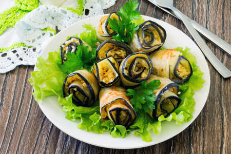 Eggplant rolls with cheese and walnuts on a wooden tableの写真素材